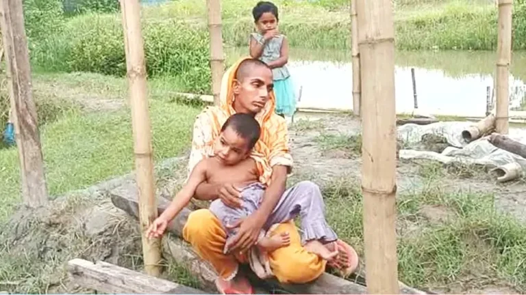 ছেঁড়া-মলিন শাড়ি পরা রেহানা খাতুন বাঁশের খুঁটির পাশে সন্তানদের নিয়ে বসে আছেন